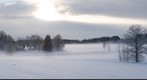 Sunlighted mist in cloudy winter evening. Riga district. Latvia.