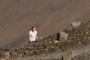 A man walking up to the crater